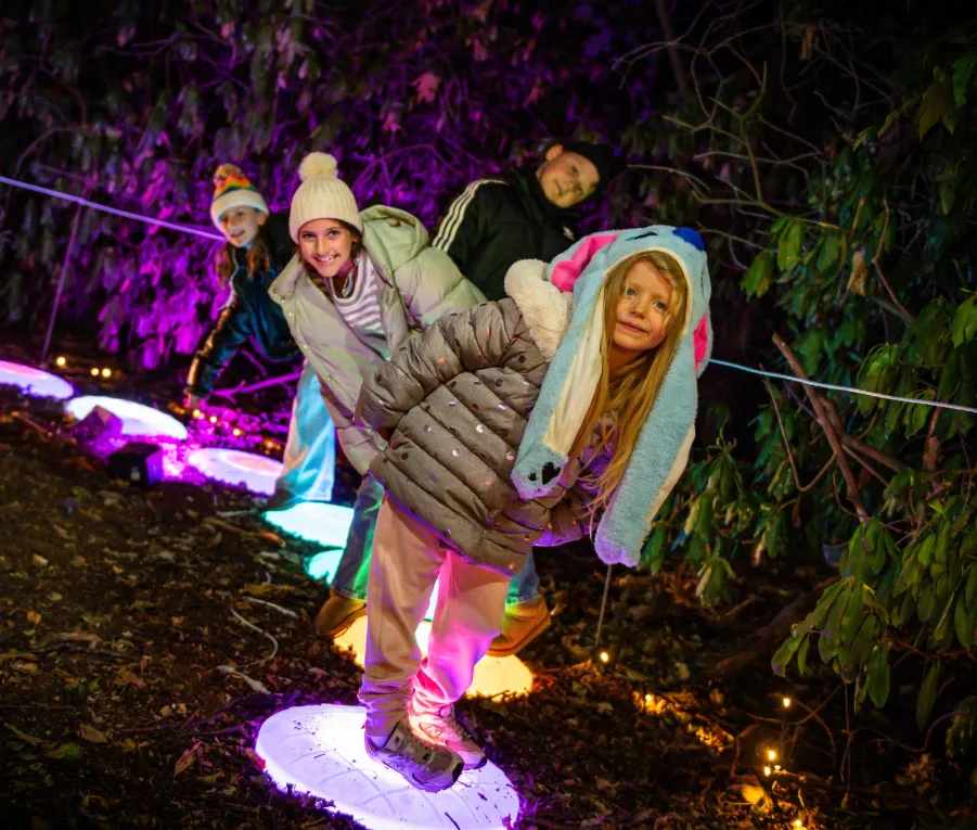 Children stepping between glowing stepping stones on the trail